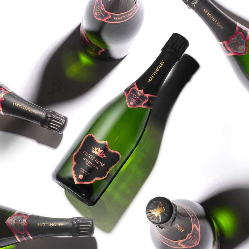 Hattingley Valley Kings Rosé Case, premium english sparkling wine, multiple Kings Rosé bottles at different angles casting shadows on the white background