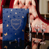Lifestyle image of Hattingley Valley Kings Cuvée with a union jack Luxury wine gift box, two glasses and a personalised bottle of wine