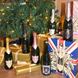 Bottles of champagne and presents under a decorated Christmas tree.