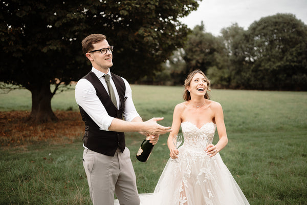 Image of newlyweds popping a bottle of Hattingley Valley Sparkling Wine, Wedding wine for wedding season