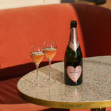 Hattingley Valley Limited edition Valentine's Rosé with heart label, valentines bottle next to two filled glasses of English Rosé, Sparkling Rosé, luxurious hotel background Joia, London