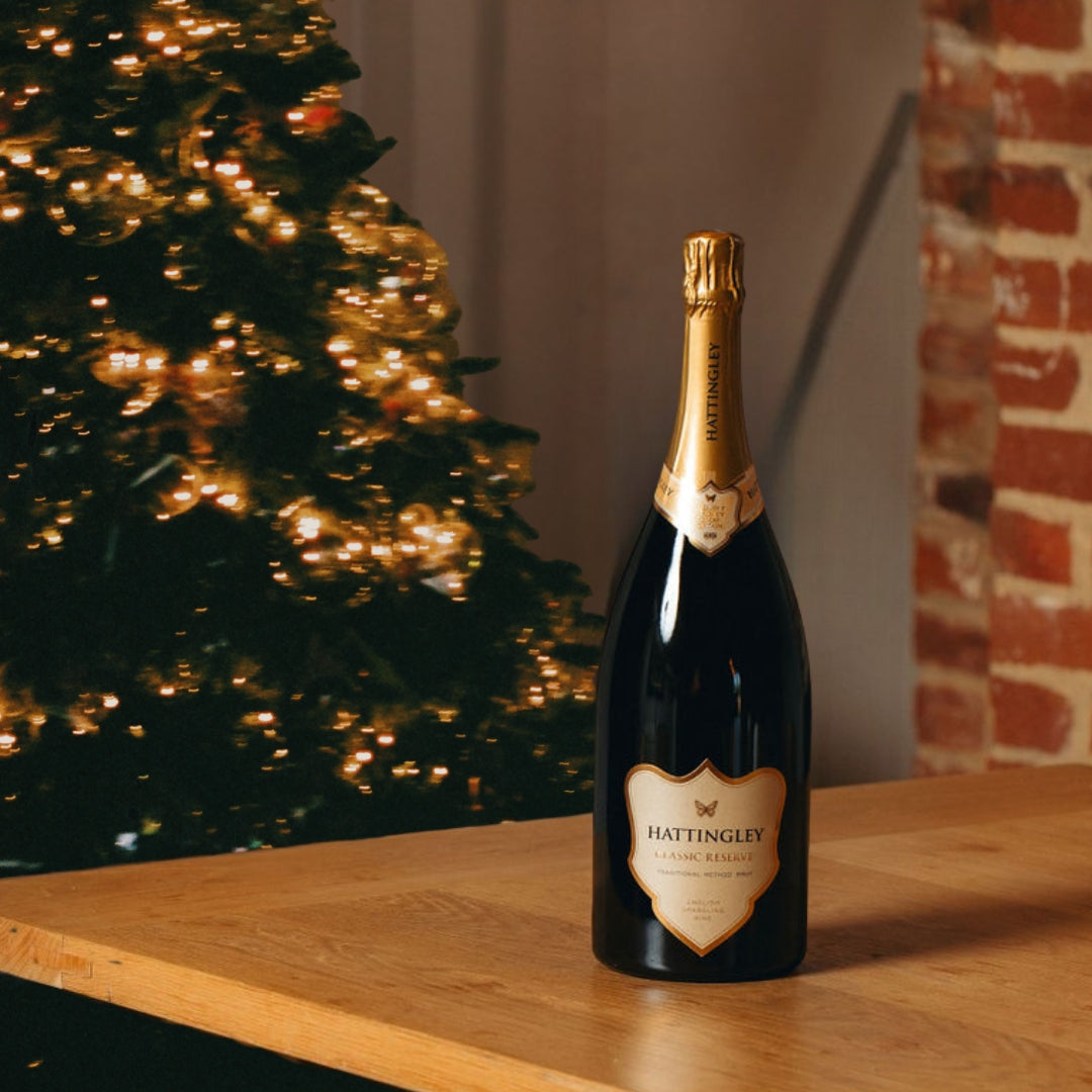 Bottle of Hattingley sparkling wine Classic Reserve NV Magnum on a wooden surface with a neutral background