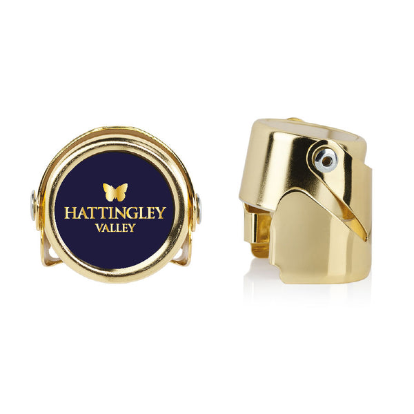 Hattingley Valley luxury sparkling wine stopper gold, viewed from both the top angle with logo and the side angle with clasp. How long does open champagne last? How to store sparkling wine?