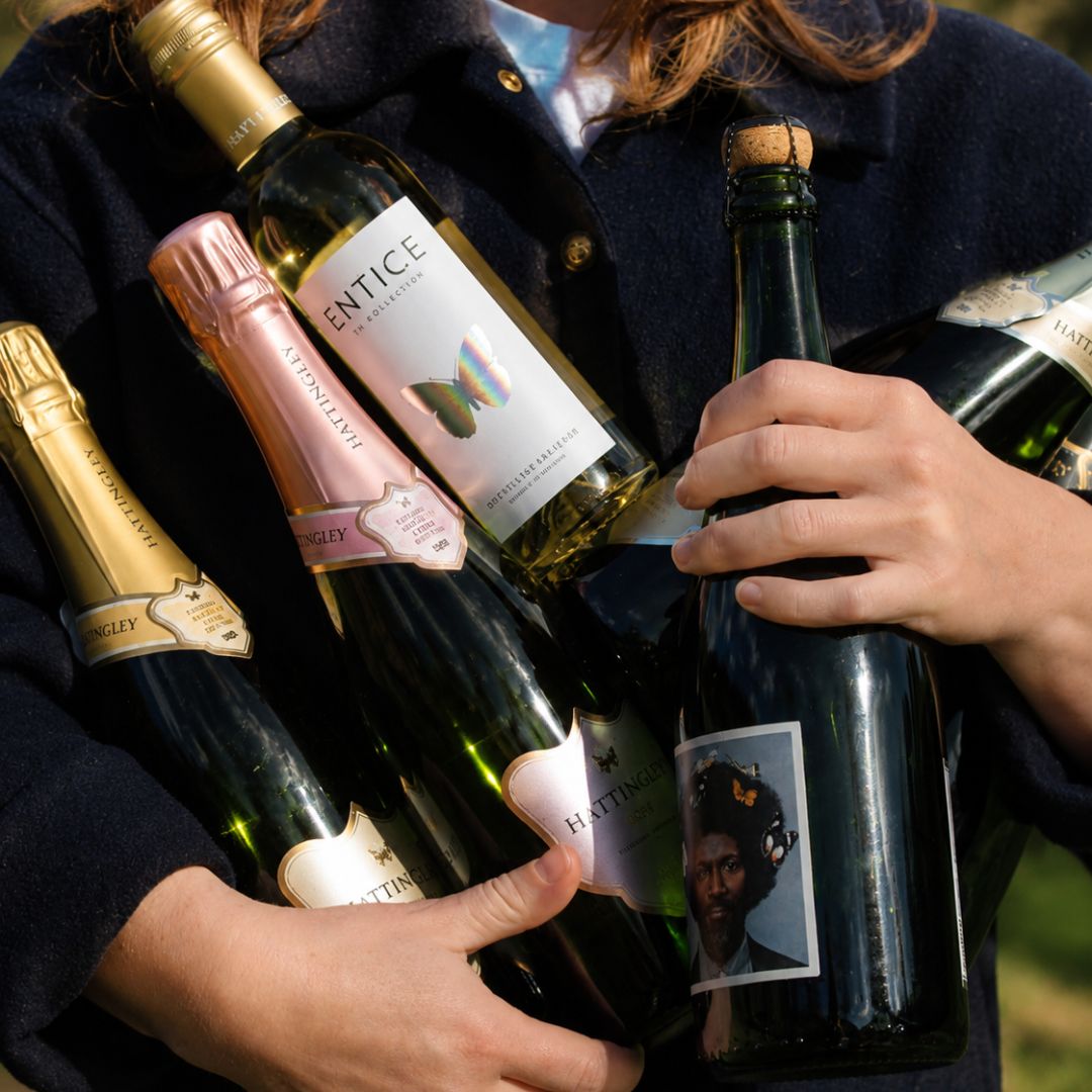 Person holding multiple bottles of Hattingley Valley English Sparkling Wine with visible labels.