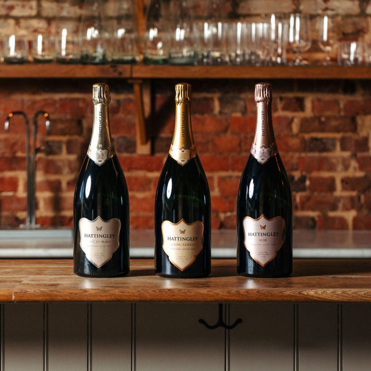 Hattingley Valley Core Collection of Magnums on a kitchen counter top. From left to right Blanc de Blancs Magnum (with silver label), Classic Reserve Magnum (with gold label) and Rosé Magnum (with pink label). Magnums of English Sparkling wine, Magnum case of three.