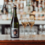 Lifestyle image, Hattingley Valley, The English Gent sparkling wine, image of filled flutes next to a bottle on a bar, background a luxurious hotel