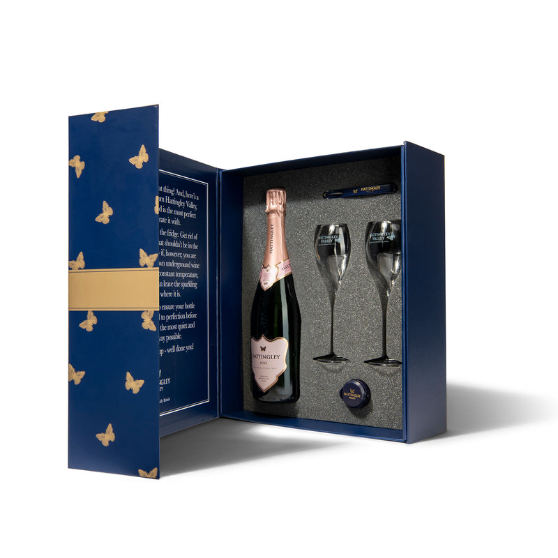 Hattingley Valley luxury gift set, box contents open, containing one bottle of Hattingley Valley English Sparkling Rosé, two tulip glass flutes, a Hattingley bottle stopper and waiters friend.