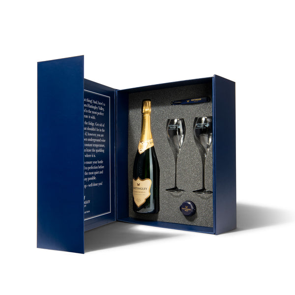 Hattingley Valley luxury gift box set. Gift box open displaying inside, with one bottle of Hattingley Valley Classic Reserve English Sparkling, two tulip flutes with the hattingley logo on them and a Hattingley bottle stopper and waiters friend.  