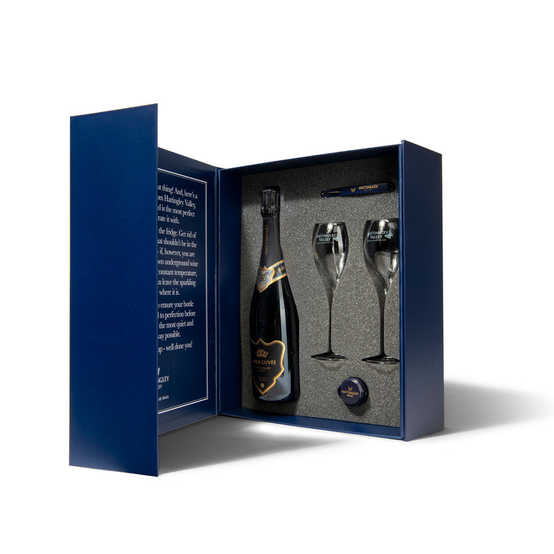 Hattingley Valley luxury gift box set. Gift box open displaying the inside, containing one bottle of Hattingley Valley Kings Cuvée Premium English Sparkling, two tulip flutes with the Hattingley logo on them and a Hattingley bottle stopper and waiters friend.