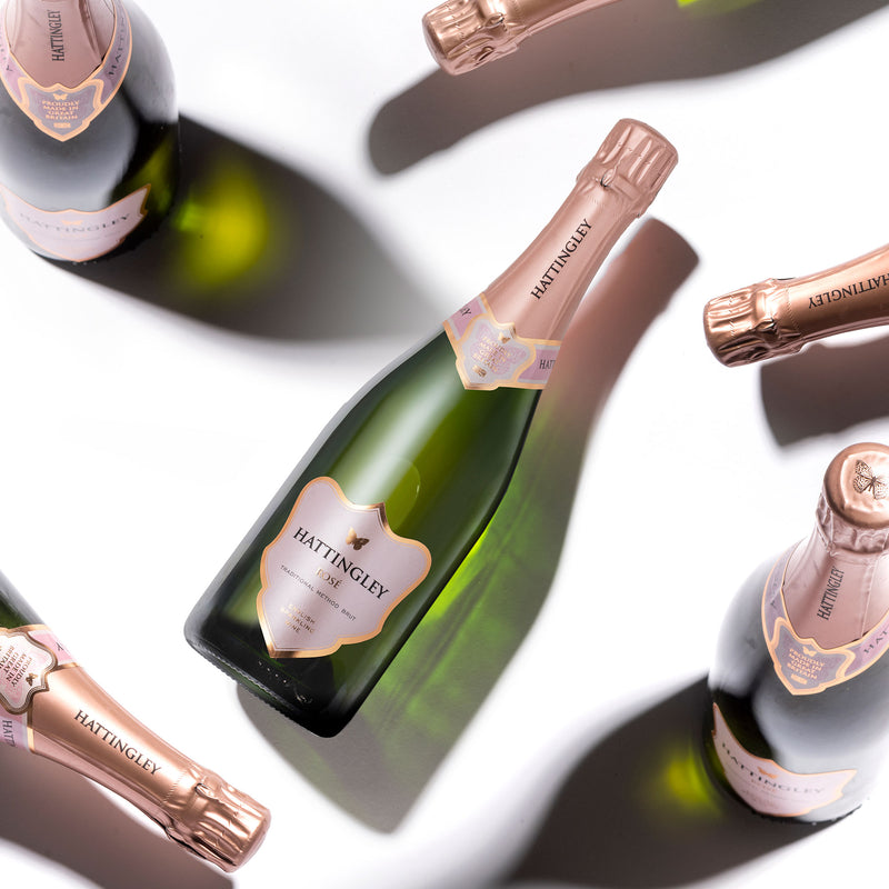 Hattingley Valley Sparkling Rosé bottles, at various angles, casting shadows on a white background 