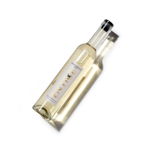 Hattingley Valley dessert wine Entice 2022, Product photo white background, pale wine in clear bottle, bottle label has gold writing with butterfly logo